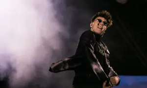 Raper w okularach i czarnym stroju na scenie. Fani zastanawiają się, dlaczego martwią się o partnerkę popularnego rapera po jego wpisie.