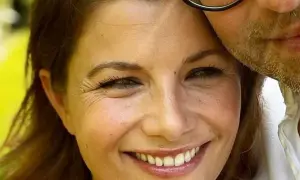 Agnieszka Sienkiewicz uśmiecha się, przytulona do swojego męża, który ma zarost i okulary.
