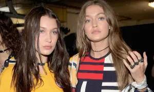 Bella Hadid i Gigi Hadid, siostry i modelki, w modnych stylizacjach. Bella ma ciemne włosy, Gigi jasne. Ich wiek jest nieistotny wobec ich talentu.