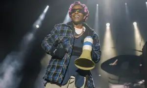 Raper A$AP Rocky, z wałkami na włosach i w kratowanej koszuli, śmieje się na scenie. Czy asap rocky żyje? Tak, i to w świetnej formie!