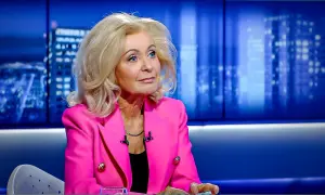 Kobieta w różowej marynarce, z blond włosami, siedzi w studiu. Ile lat ma Krystyna Hołc? Trudno zgadnąć, wygląda świetnie!