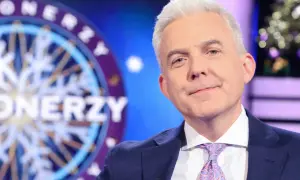 Hubert Urbański w garniturze i krawacie, na tle koła z napisem "Milionerzy". Czy to jego ostatnie chwile w programie i dlaczego znana dziennikarka przeszła do konkurencji bez pożegnania z widzami?