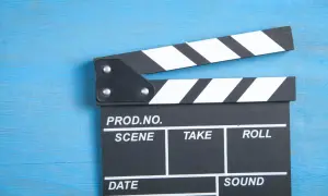 Klapka filmowa na niebieskim tle. Zastanawiasz się, ile zarabiają polscy aktorzy za jeden dzień zdjęciowy w hicie kinowym?