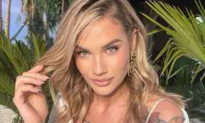 Karolina Gilon z burzą blond włosów i tatuażami na ramieniu, otoczona palmami. Ciekawe, ile lat ma Karolina Gilon?