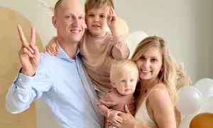 Katarzyna z mężem i dziećmi, uśmiechnięci, w otoczeniu balonów.