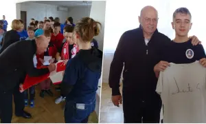 Starszy mężczyzna podpisuje koszulkę dla grupy dzieci, a potem pozuje z młodym chłopcem trzymającym podpisaną koszulkę.