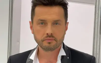 Piotr Cugowski, znany z zespołu Bracia, prezentuje się elegancko w czarnej marynarce. Ile lat ma Piotr Cugowski?