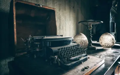 Stara maszyna do pisania w kufrze, obok lampka i ozdobne kule. Czy to tu gwiazdy piszą autobiografie z pomocą ghostwriterów?
