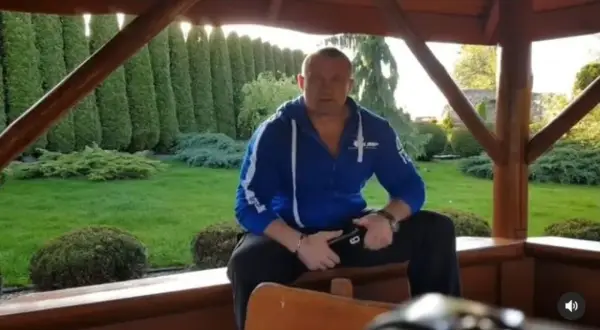 Mariusz Pudzianowski w swojej posiadłości, gdzie mieszka. W tle zadbany ogród z żywopłotem.