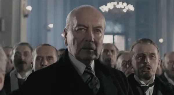 Starszy mężczyzna z wąsami i grupą ludzi w tle. Czy to scena z filmu, która ukazuje największe błędy historyczne w polskich filmach, o których milczą twórcy?
