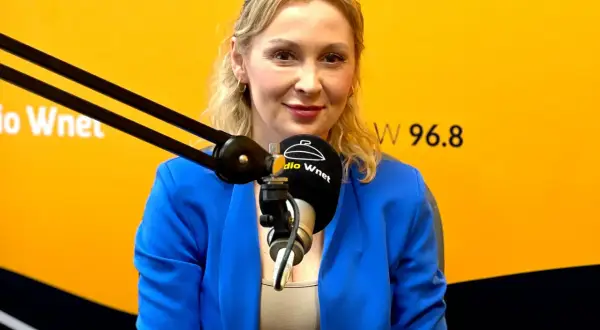 Joanna Miziołek, w wieku około 40 lat, w niebieskiej marynarce, udziela wywiadu w Radiu Wnet.
