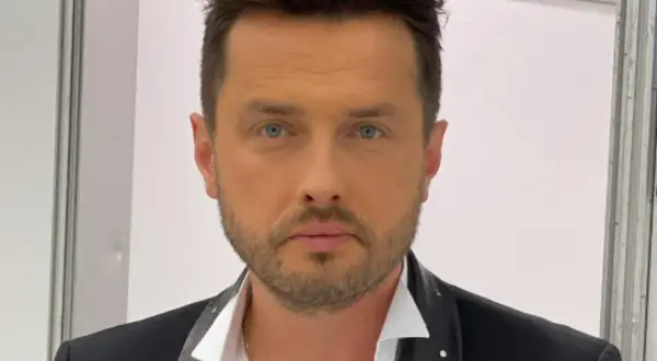 Piotr Cugowski, znany z zespołu Bracia, prezentuje się elegancko w czarnej marynarce. Ile lat ma Piotr Cugowski?
