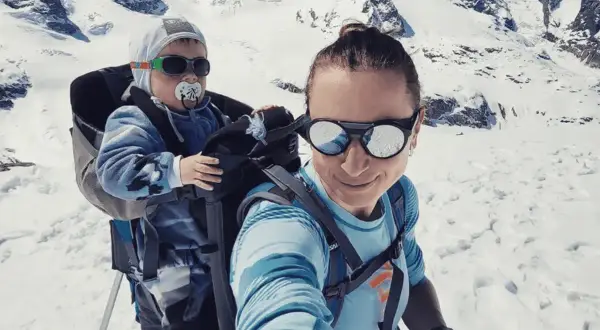Justyna Kowalczyk z synkiem w nosidle w górach. To jej jedyne dziecko.
