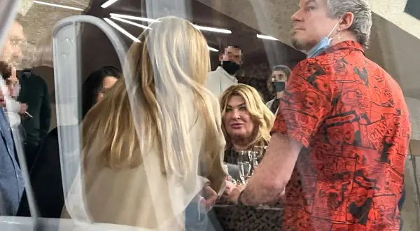Mężczyzna w czerwonej koszuli z komiksowym wzorem, być może to on jest partnerem Beaty Kozidrak, siedzi przy stole z innymi osobami.