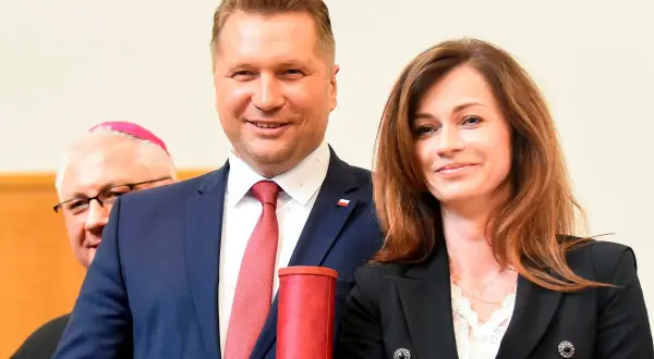 Przemysław Czarnek z żoną, Katarzyną, podczas uroczystości. Z tyłu widoczny biskup.