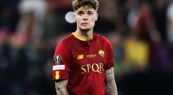 Młody piłkarz Nicola Zalewski w koszulce AS Roma, z tatuażami na ramionach. Warto wiedzieć, ile lat ma Nicola Zalewski, by docenić jego talent.