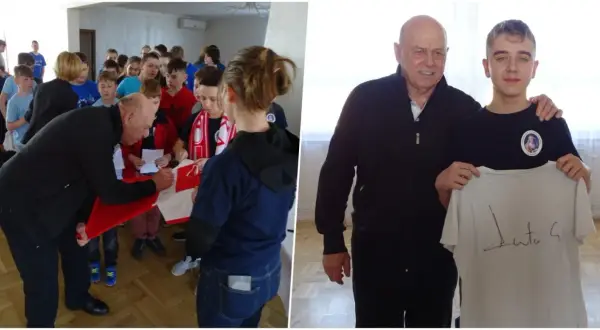 Starszy mężczyzna podpisuje koszulkę dla grupy dzieci, a potem pozuje z młodym chłopcem trzymającym podpisaną koszulkę.