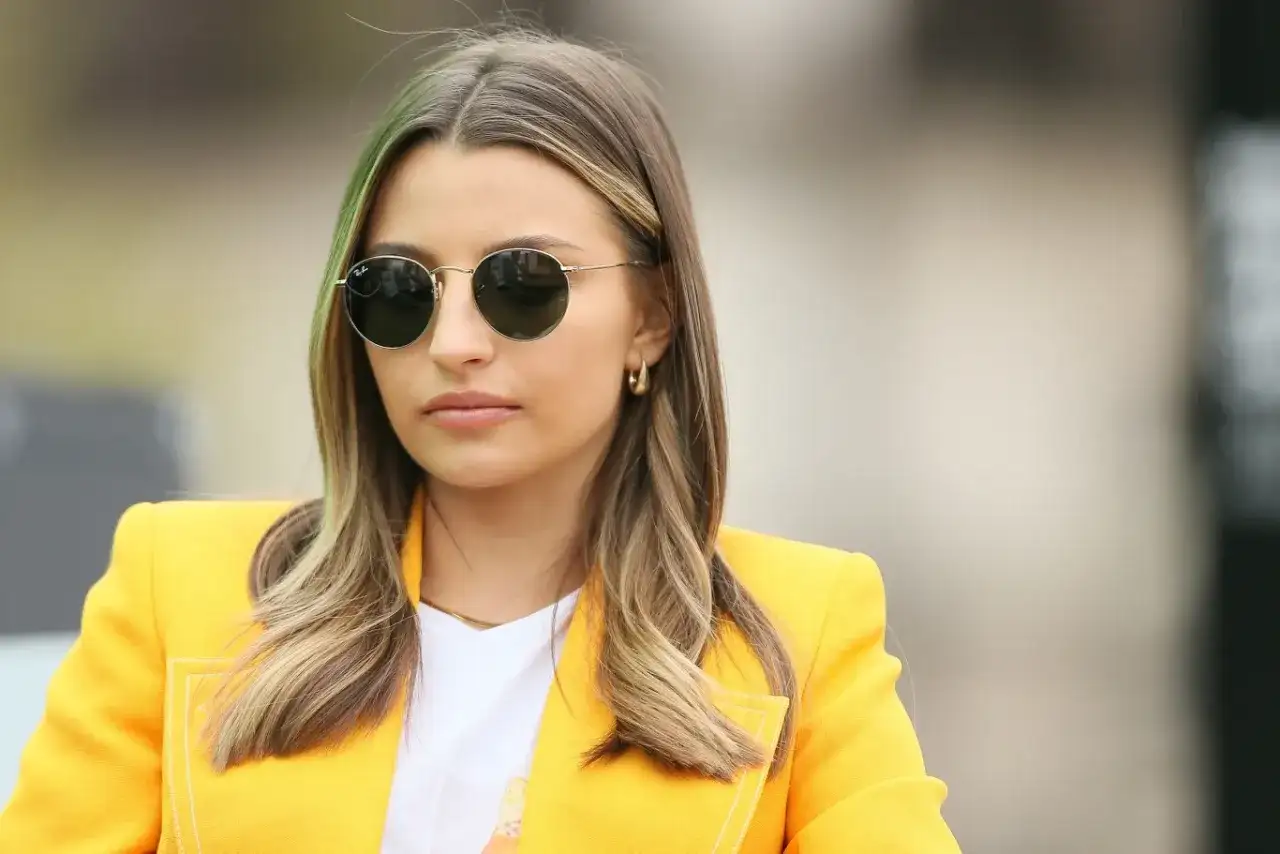 Prawda o pochodzeniu majątku rodziny najbogatszej polskiej it-girl. Młoda kobieta w okularach przeciwsłonecznych i żółtej marynarce.