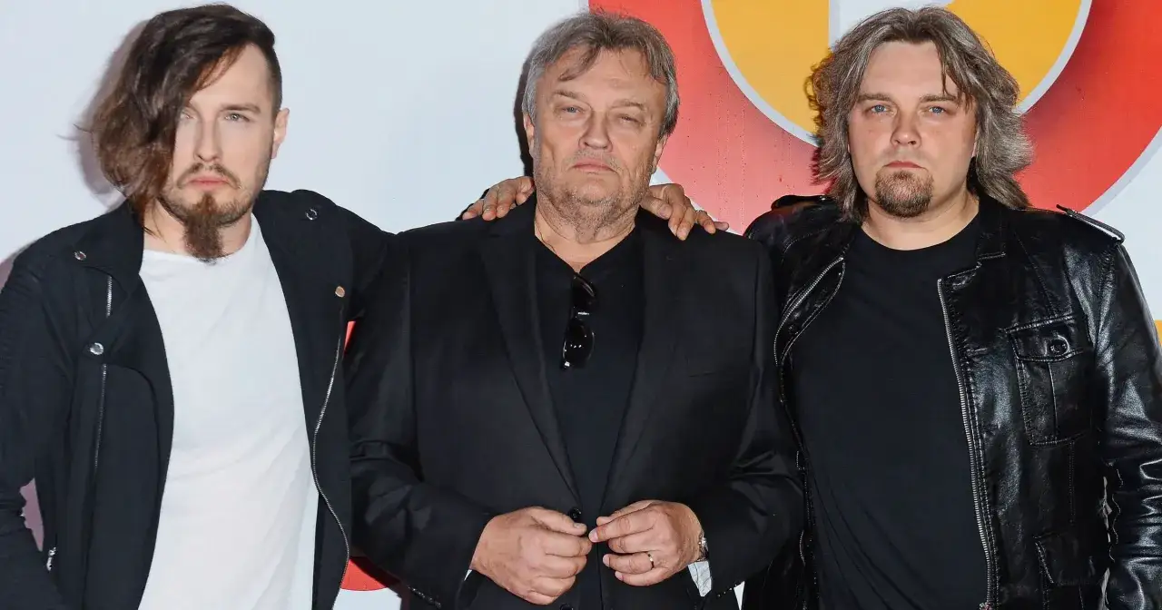 Trzech mężczyzn, w tym Piotr Cugowski, pozuje do zdjęcia.