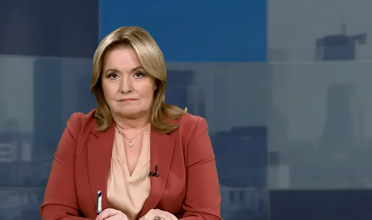 Kobieta w czerwonej marynarce, dziennikarka, wyjaśnia, dlaczego ikona telewizji zniknęła z mediów na ponad pół roku.