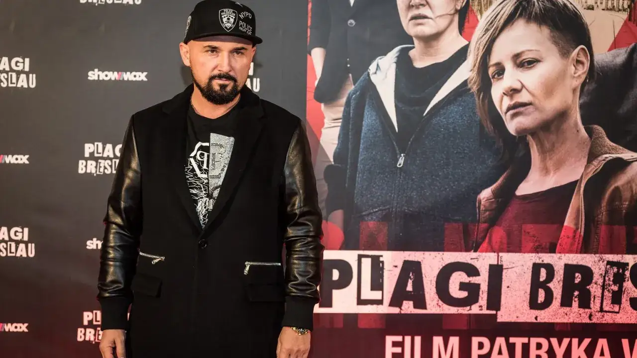 Patryk Vega, znany z kontrowersyjnych polskich filmów akcji, na tle plakatu