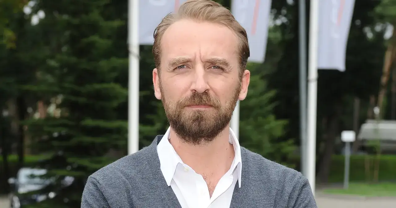 Mężczyzna z brodą w szarym swetrze. Czy to on ma najwięcej dubli przez zapominanie tekstu?