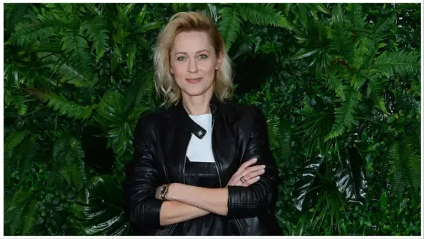 Lea Oleksiak, w czarnej ramonesce, na tle bujnej zieleni. Jej życie prywatne budzi zainteresowanie.