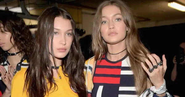 Bella Hadid i Gigi Hadid, siostry i modelki, w modnych stylizacjach. Bella ma ciemne włosy, Gigi jasne. Ich wiek jest nieistotny wobec ich talentu.