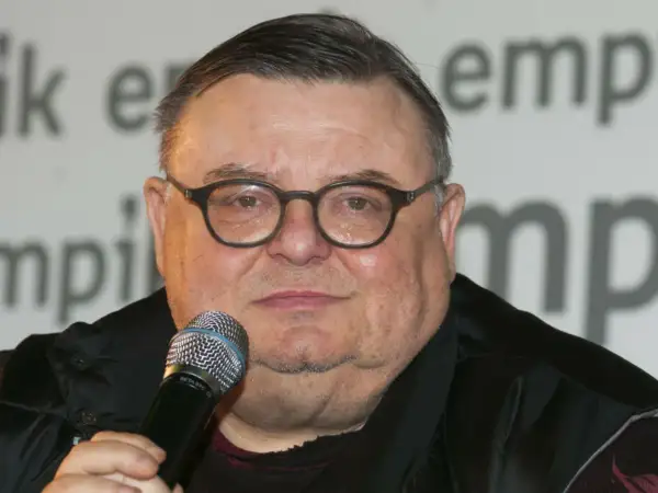 Wojciech Mann, znany z audycji radiowych, w okularach i z mikrofonem. Jego wiek nie jest widoczny na zdjęciu.